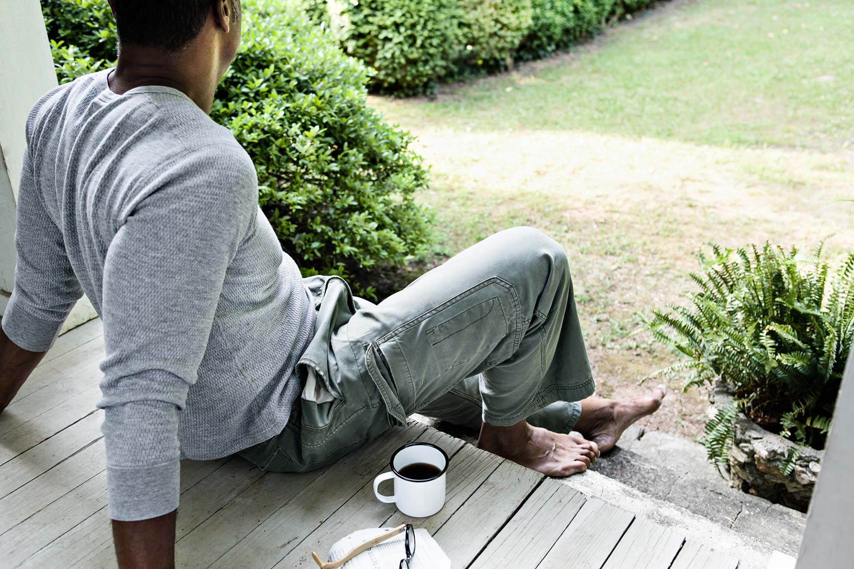 African American man relaxes with coffee on steps of home, Atlanta