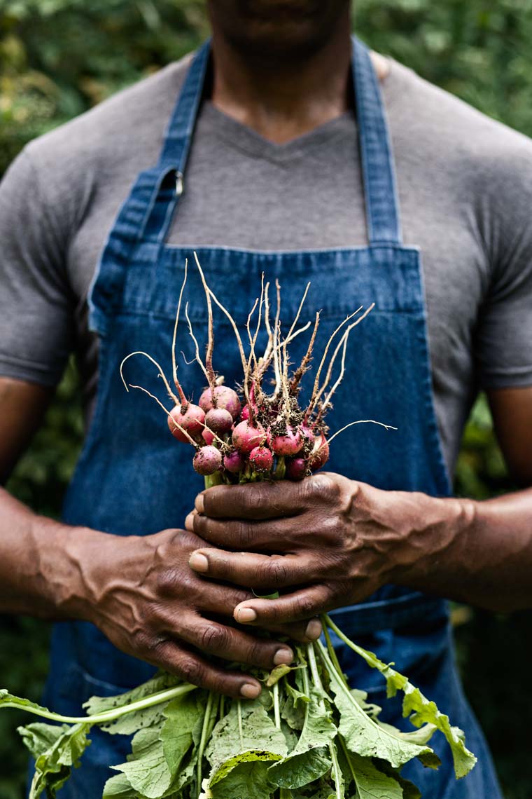 Tight portrait of African American farmer holding vegetables, Atlanta 