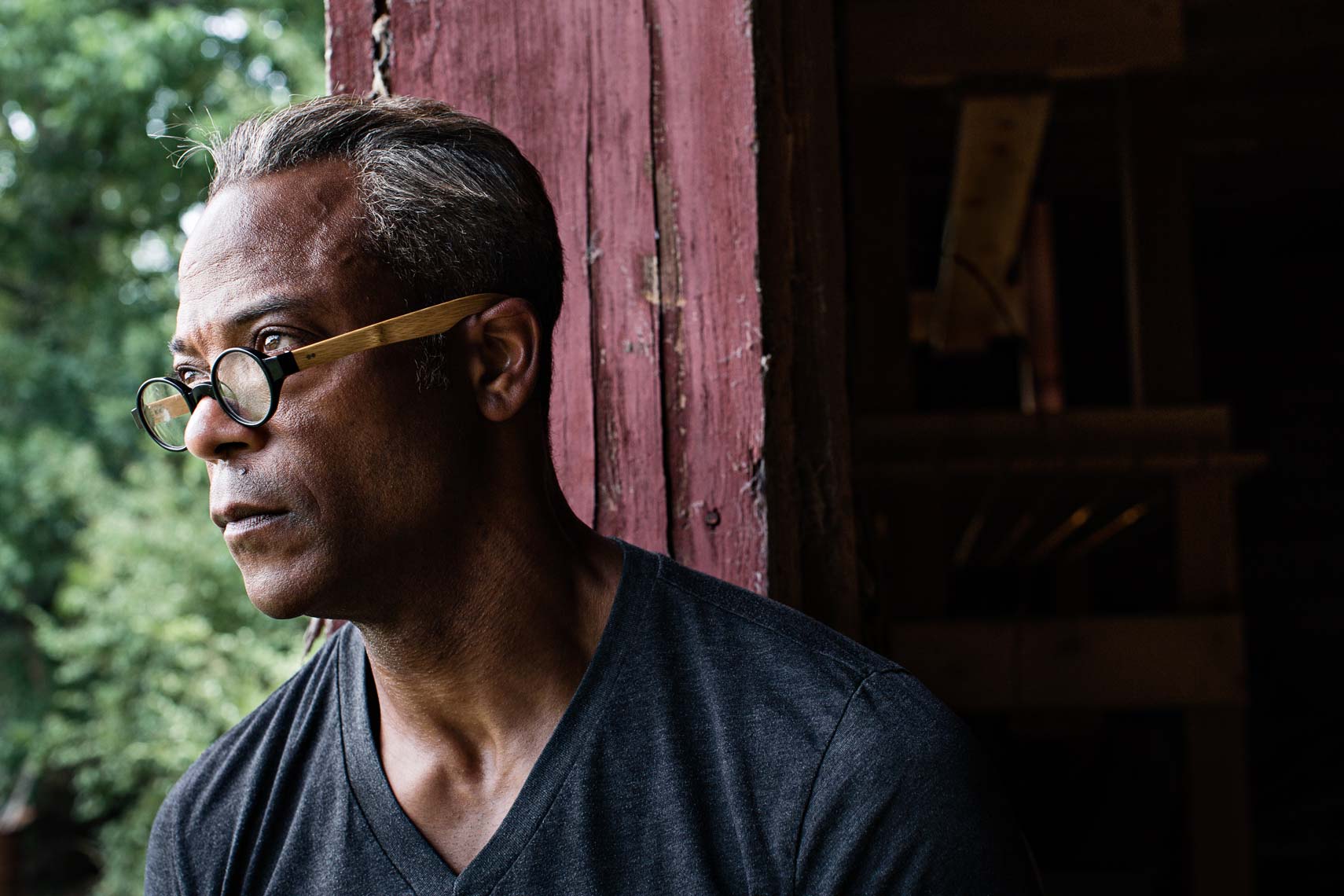 African American man with glasses looks from doorway of barn, Atlanta
