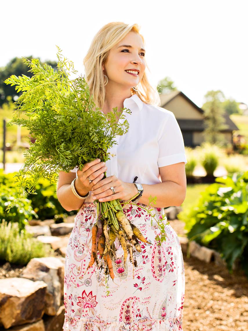 Female chef in garden holding bunch of carrots. Atlanta portrait photography