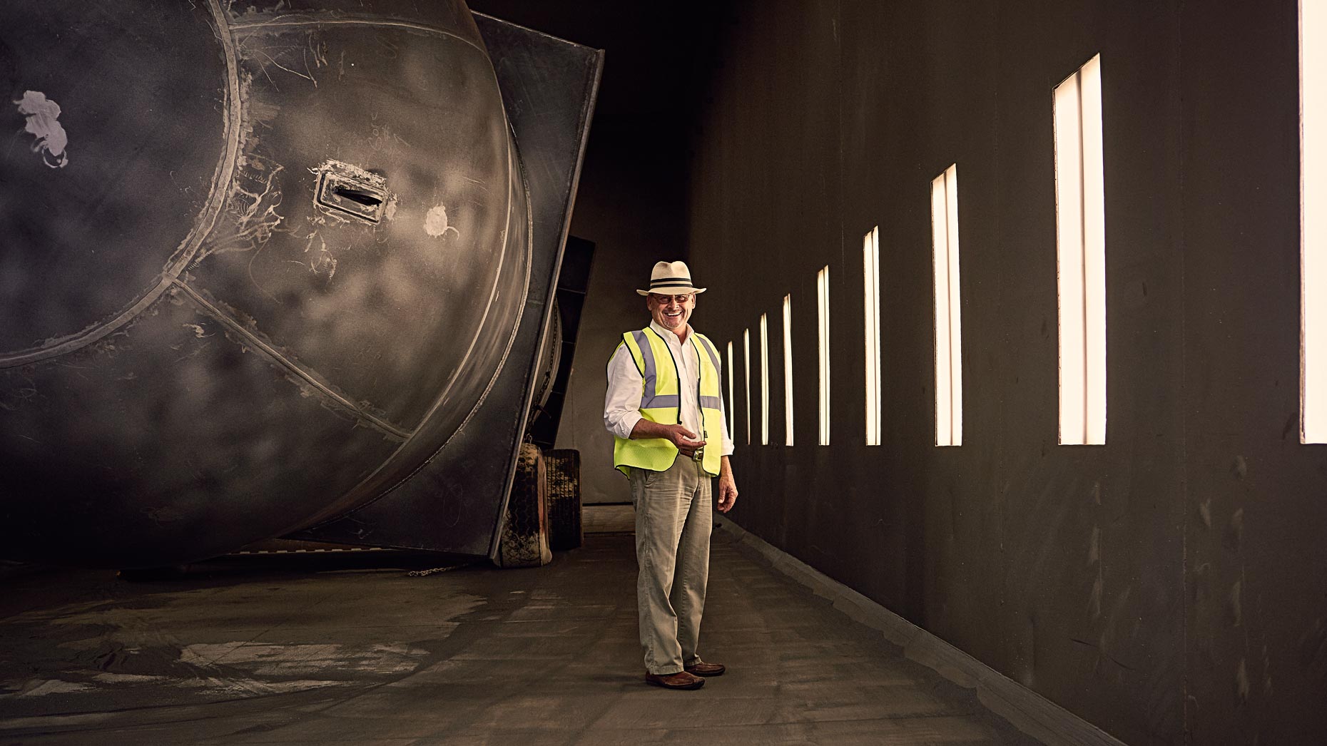 Portrait of man wearing hard hat inside large industrial space, Atlanta