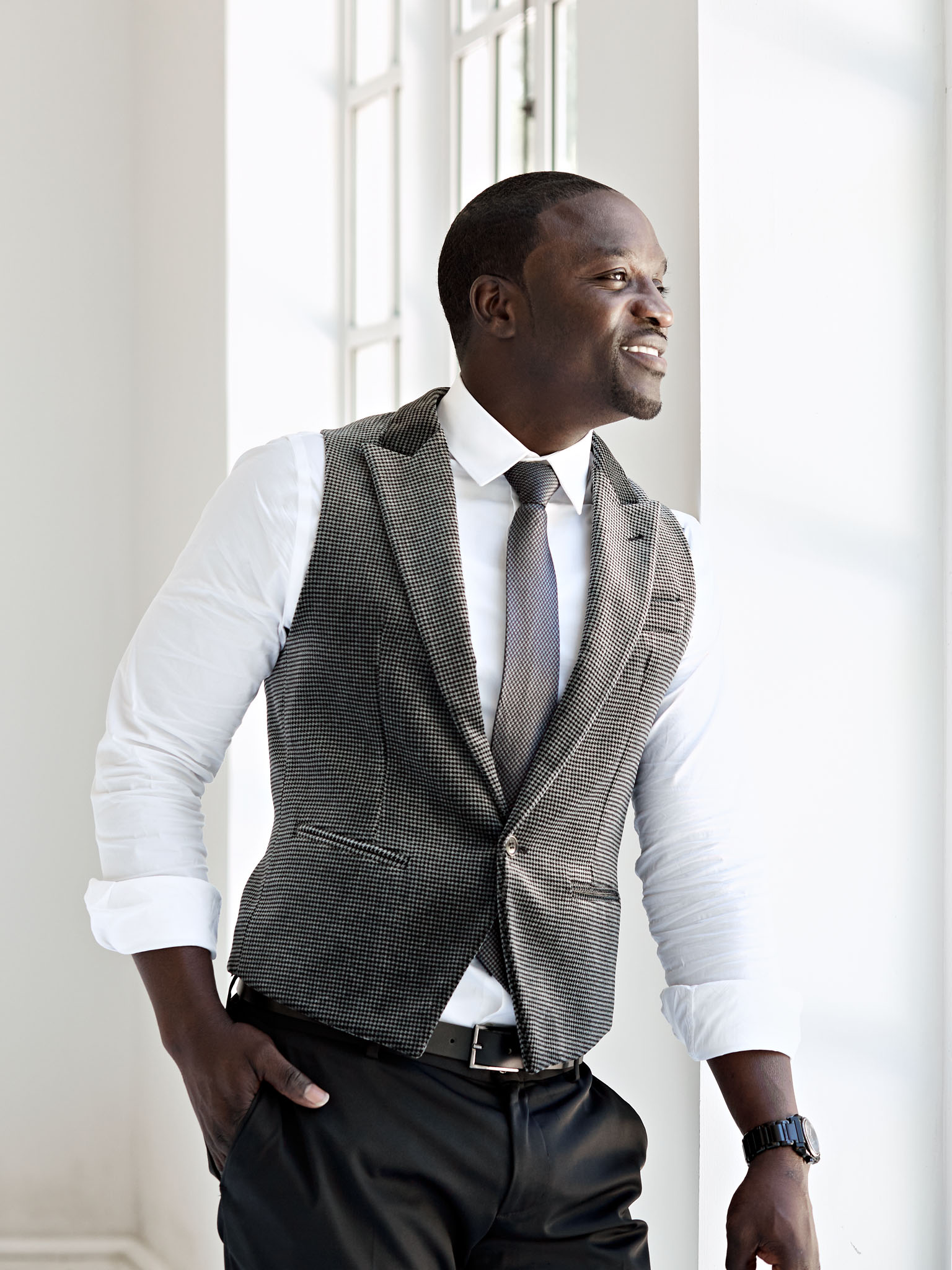 Editorial photograph of Atlanta rapper Akon standing at window